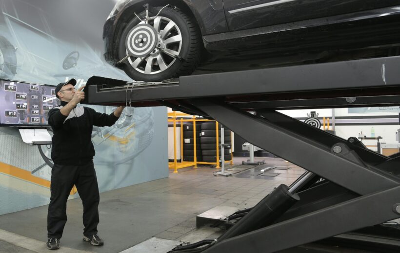 mechanic repairing car after collision